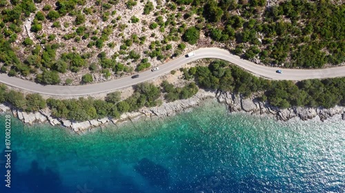 4K Drone footage of casr moving by the sea curved road near a tranquille waves on the Greek coast on Cephalonia island. Transportation, nature concept. photo