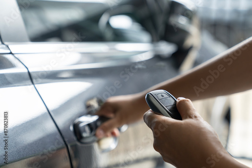 Hand holding keyless car and opening the door © virojt