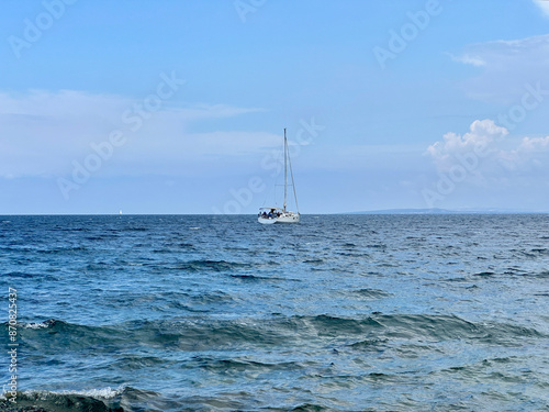 A white sailboat sails on the blue sea. Boat with a sail on the birch water of the Adriatic sea. Sailing holidays off the Croatian coast, Preko island, June 27, 2024 photo