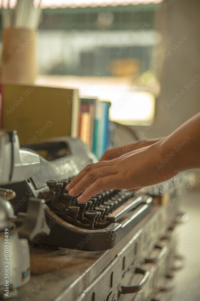 an asian woman hands typing on an old typing machine an asian woman hands typing on an old typing machine