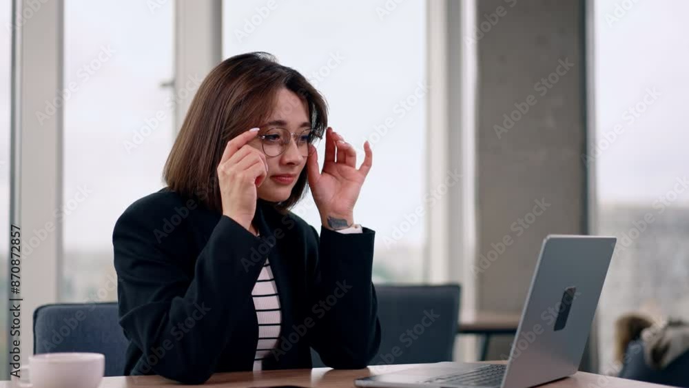 Beautiful woman sitting in front of laptop takes off her glasses. Time for break from work or the end of the working day. Beautiful woman sitting in front of laptop takes off her glasses. Time for break from work or the end of the working day.
