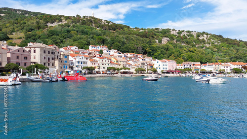 Picturesque town on a croatian island with tourists relaxing by the sea on a sunny summer day