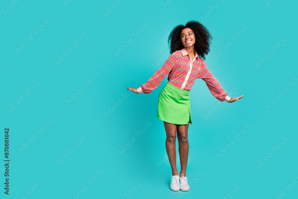 Full length photo of cheerful pretty lady dressed print blouse dancing looking empty space isolated blue color background Full length photo of cheerful pretty lady dressed print blouse dancing looking empty space isolated blue color background