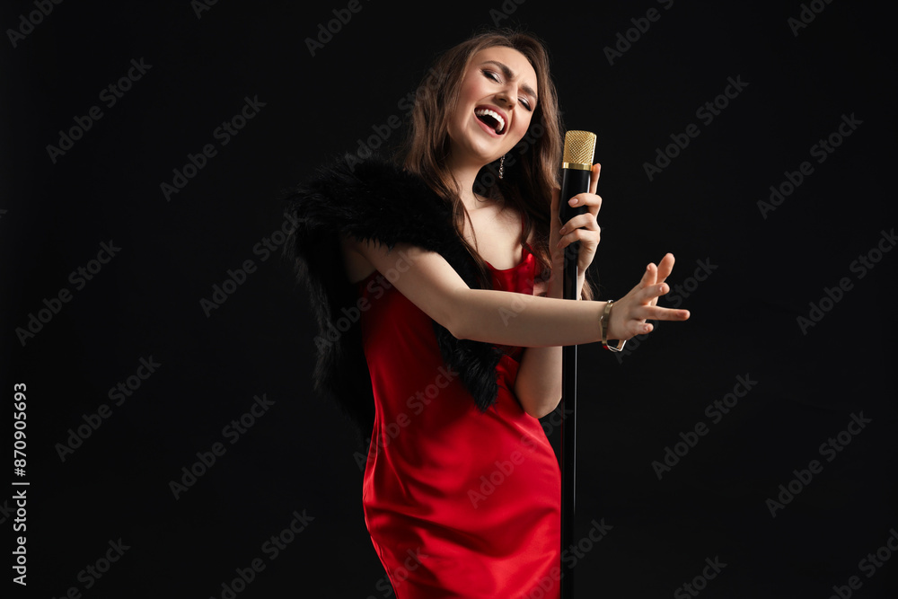 Beautiful young woman in stylish dress with microphone singing on black background Beautiful young woman in stylish dress with microphone singing on black background