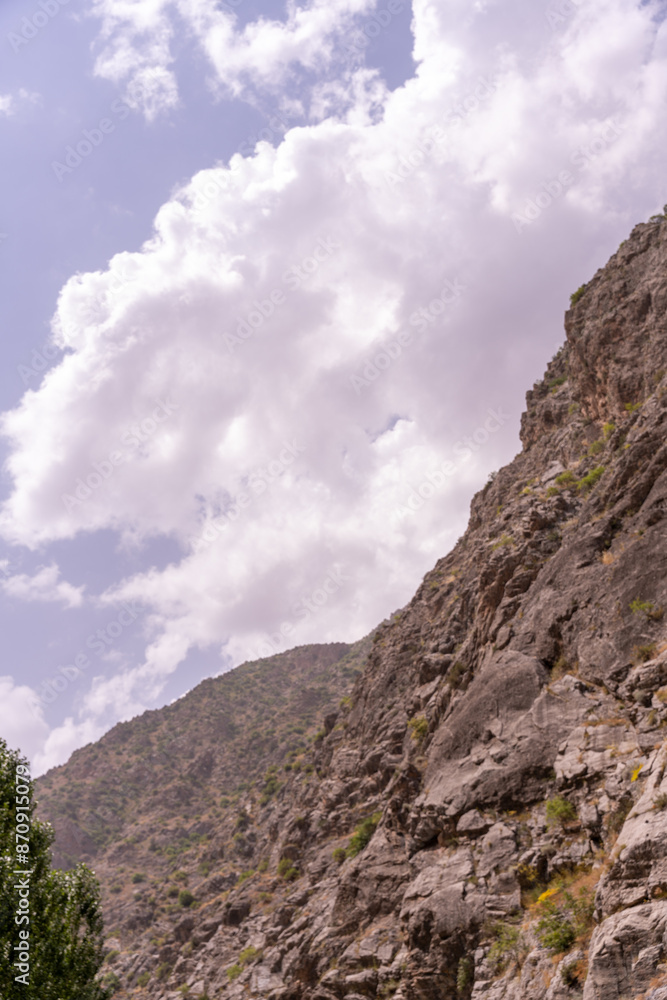 Naklejka premium A mountain range with a cloudy sky in the background