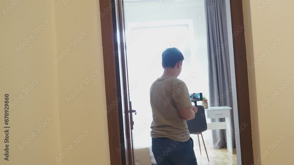 Young boy blogger making selfie using smartphone in a hotel room enjoying her vacation. Tourist with suitcase and backpack making online room tour. teenager shoots content for social networks Young boy blogger making selfie using smartphone in a hotel room enjoying her vacation. Tourist with suitcase and backpack making online room tour. teenager shoots content for social networks