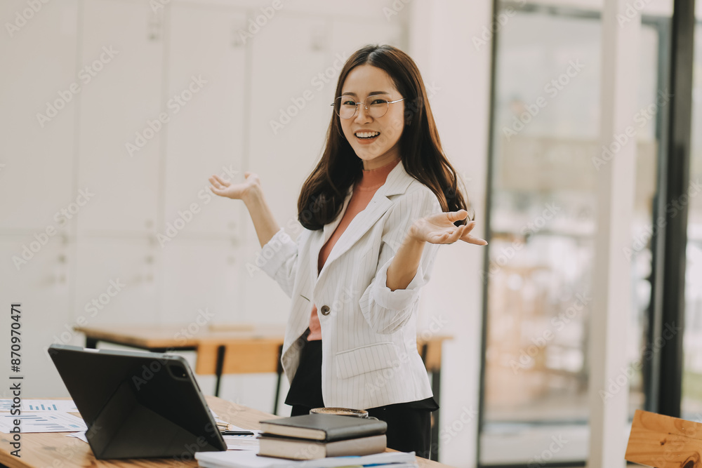 Happy young asian businesswoman sitting on her workplace in the office. Young woman working at laptop in the office. Happy young asian businesswoman sitting on her workplace in the office. Young woman working at laptop in the office.