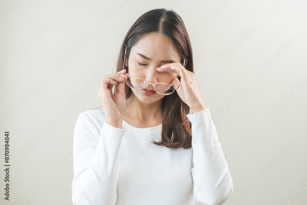 Eye problem concept, fatigue asian young woman tired eyes irritated rubbing, massage eye dry relief vision pain after work, eye strain, hand holding glasses, suffer bad blurry isolated on background. Eye problem concept, fatigue asian young woman tired eyes irritated rubbing, massage eye dry relief vision pain after work, eye strain, hand holding glasses, suffer bad blurry isolated on background.