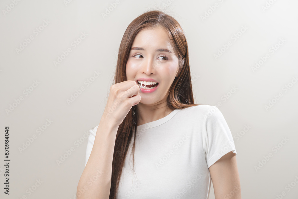 Flossing teeth, dental care hygiene, asian young woman flossing teeth with dental floss pick, smile happy with perfect white teeth, using tooth floss cleaning, healthy teeth isolated on background. Flossing teeth, dental care hygiene, asian young woman flossing teeth with dental floss pick, smile happy with perfect white teeth, using tooth floss cleaning, healthy teeth isolated on background.