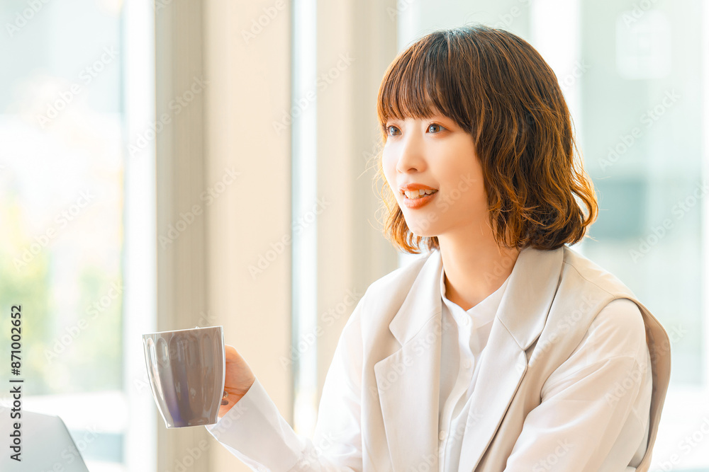 マグカップを持って話すビジネスウーマン