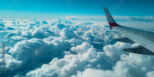 Airplane Wing Over Fluffy Clouds and Blue Sky A Serene Mid flight Perspective photo