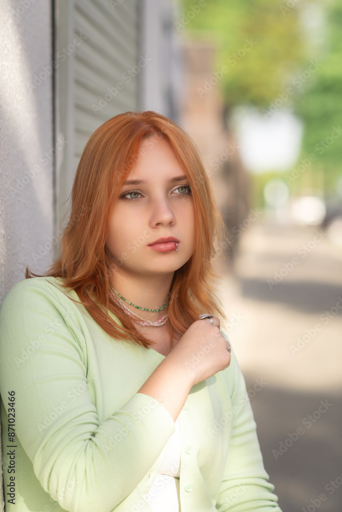 Portrait of a young beautiful red-haired girl in an urban environment. Portrait of a young beautiful red-haired girl in an urban environment.