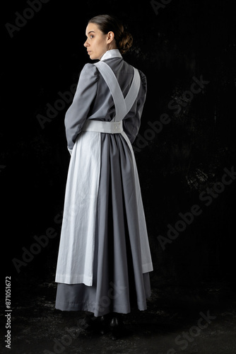 World War 1 nurse wearing a grey dress and white apron