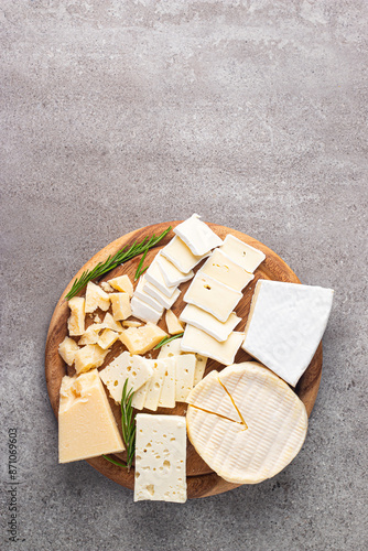 Wooden board with various cheese and olives. Brie. Camembert. Parmesan, feta, blue cheese. Italian, French cheese.