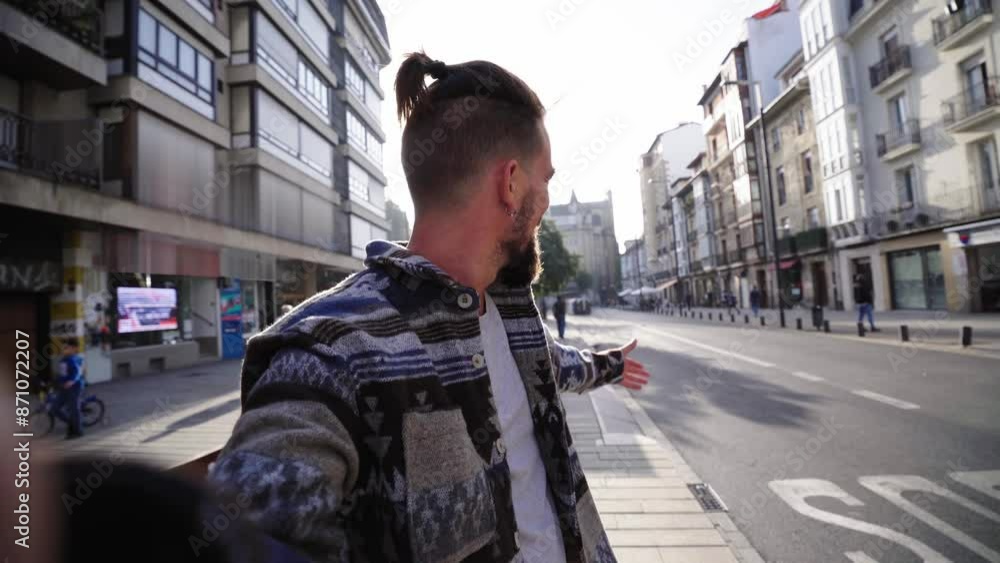 Caucasian man doing a video call with family and friends while being outdoors with a cityscape in the background, waving and talking to the camera cheerfully, showing the city. Caucasian man doing a video call with family and friends while being outdoors with a cityscape in the background, waving and talking to the camera cheerfully, showing the city.