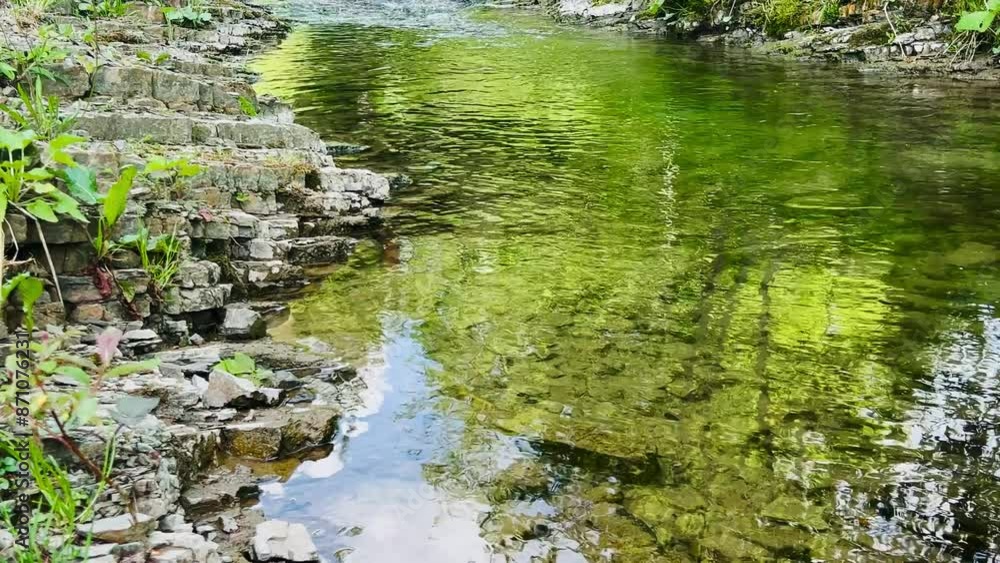 A transparent mountain river flows among the stones. A transparent mountain river flows among the stones.