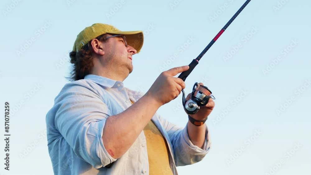 a fisherman catches a fish on a river on a summer day a fisherman catches a fish on a river on a summer day