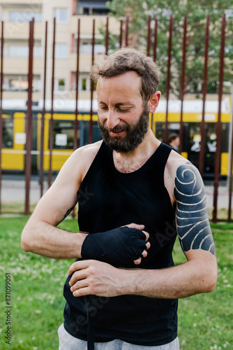 Man Wrapps his hand for Muay Thai training outside photo