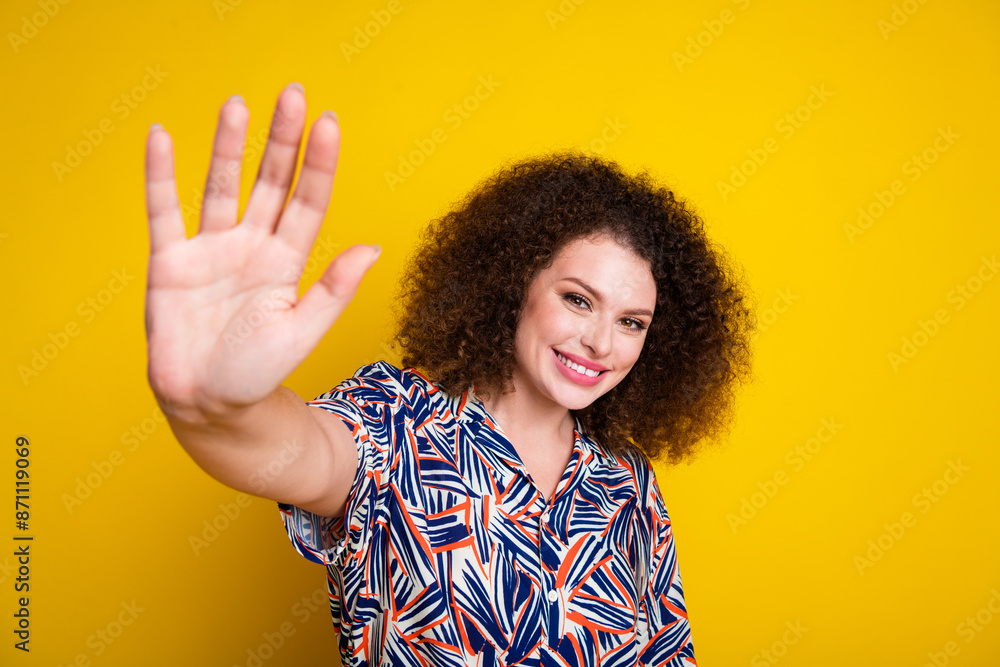 Photo portrait of attractive young woman wave hand hello dressed stylish colorful clothes isolated on yellow color background Photo portrait of attractive young woman wave hand hello dressed stylish colorful clothes isolated on yellow color background