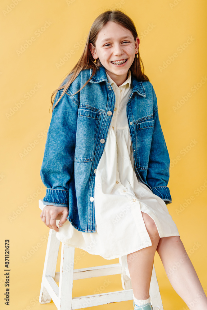 © Melissa Milis Photography/Stocksy - Smiling girl sitting in studio