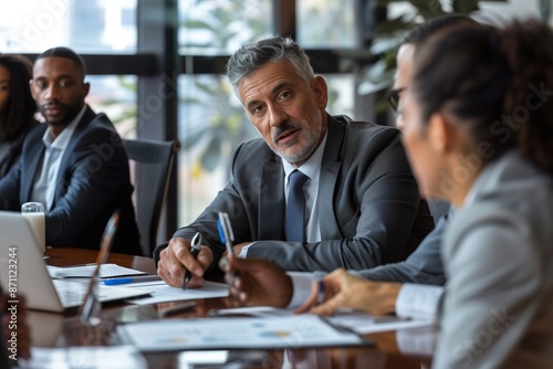 Male mature caucasian ceo businessman leader with diverse coworkers team, executive managers group at meeting. Multicultural professional businesspeople working together on research plan in boardroom.