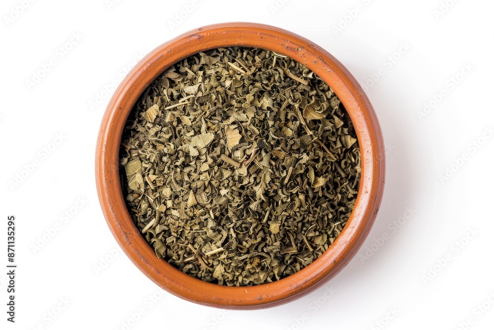 Close up photo of mate tea leaves in a brown ceramic bowl on white background Close up photo of mate tea leaves in a brown ceramic bowl on white background
