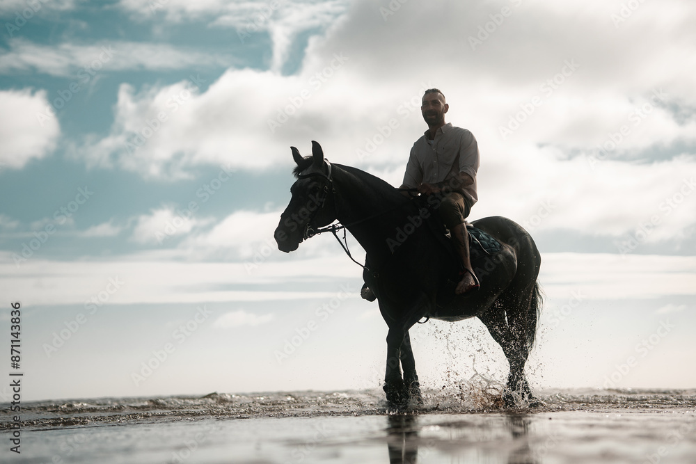 Man riding a horse on a beach, equestrian coastline scene, cowboy on horseback