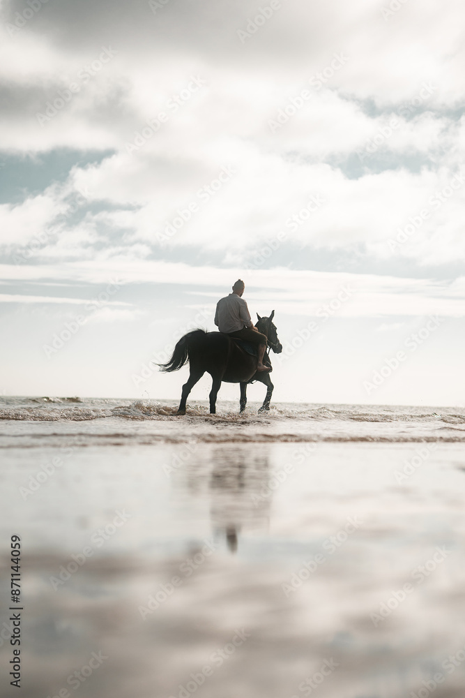 Man riding a horse on a beach, equestrian coastline scene, cowboy on horseback Man riding a horse on a beach, equestrian coastline scene, cowboy on horseback