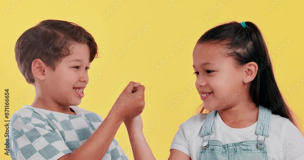 Happy kids, hands together and trust with pinky promise for secret, agreement or deal in studio on a yellow background. Young children or best friends with finger, swear or honesty for friendship