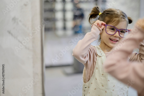 a child tries on glasses in an optical shop photo