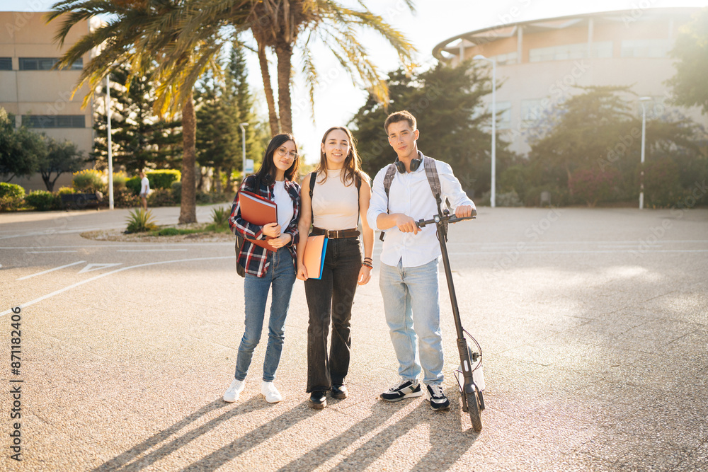 Confident students with notebooks and rucksack on pavement Confident students with notebooks and rucksack on pavement