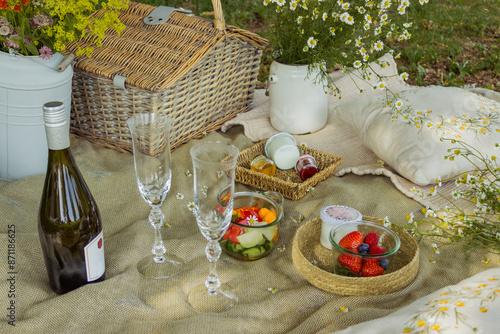 Beautiful white boho style decor. Picnic in nature on the grass under the tree photo