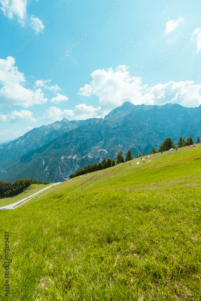 Fototapeta premium Paraglider Starting to Fly on a Hill in the Mountain Landscape