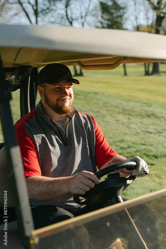 young man driving a golf cart on the golf course young man driving a golf cart on the golf course