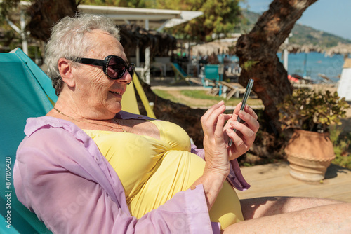 Woman using smartphone at beach photo