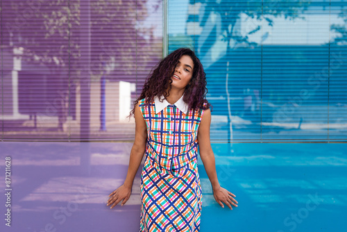 Happy curly haired model standing on street photo