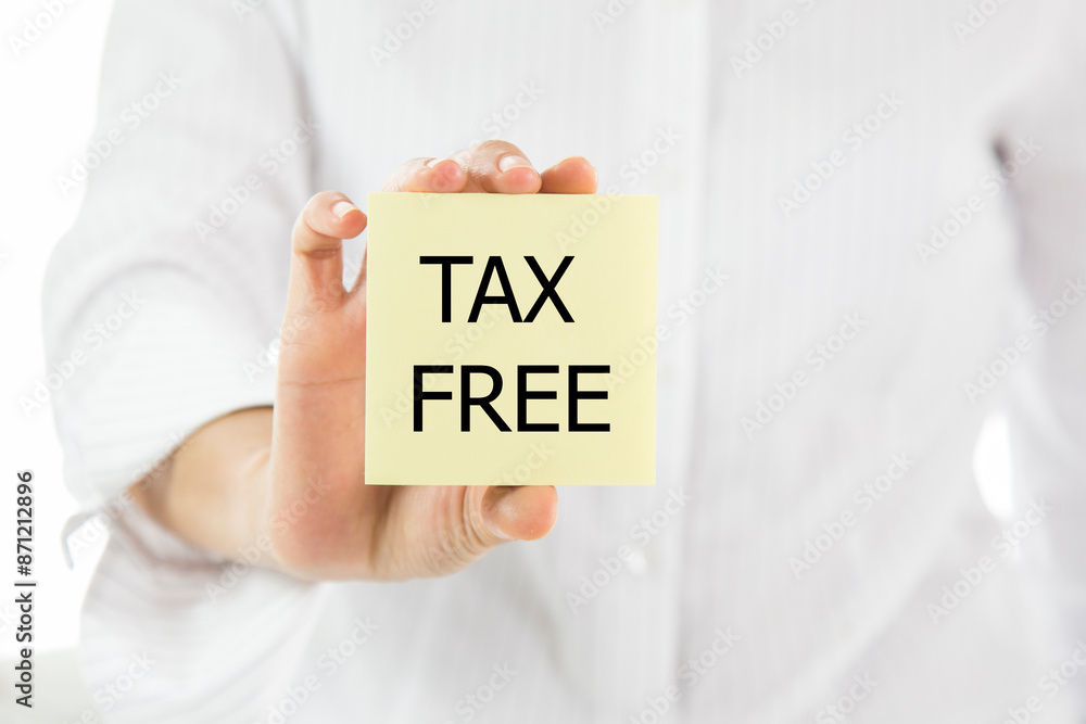 A person is holding a yellow sticky note that says tax free A person is holding a yellow sticky note that says tax free