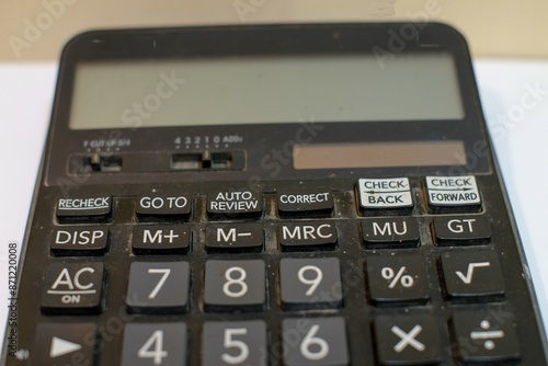 A black digital calculator isolated on white background. top view, copy space, closeup.