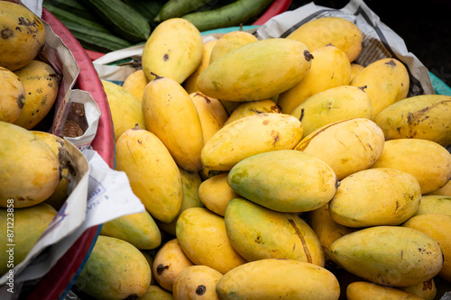 A pile of ripe mango fruit for sale at an outdoor market in Cambodia
