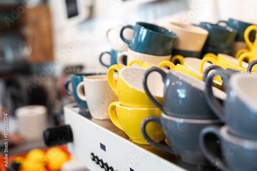Colorful ceramic mugs on display in a coffee shop