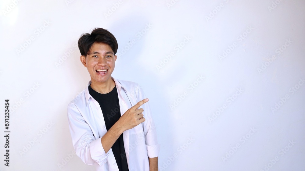 Excited young Asian man gesturing pointing to the side Excited young Asian man gesturing pointing to the side