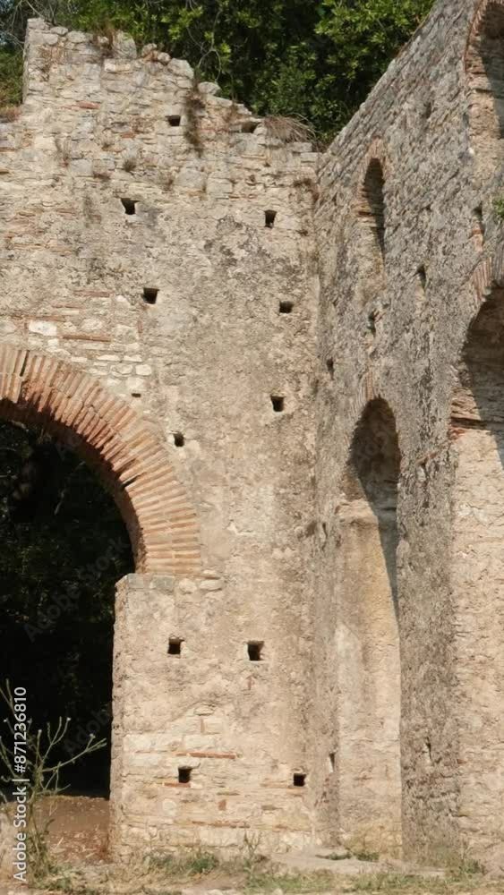 A tourist visiting The Great Basilica in the archaeological ruins of Butrint or Butrinto National Park in Albania. A tourist visiting The Great Basilica in the archaeological ruins of Butrint or Butrinto National Park in Albania.