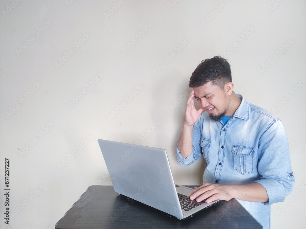 A man at work experienced a severe headache after working on a laptop A man at work experienced a severe headache after working on a laptop