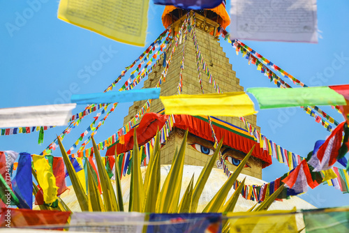 Boudhanath stupa with colorful prayer flags on a bright day photo