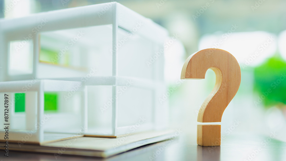 Question mark and house model on a table. Planning to buy property ...