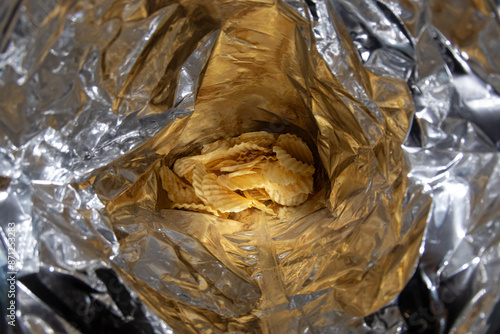 Golden, ridged potato chips - inside a foil bag - close-up view. Taken in Toronto, Canada. photo