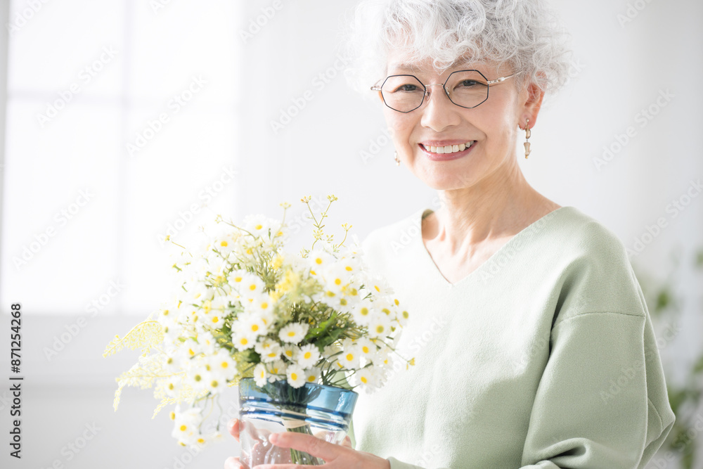 Senior woman with flowers in her room Hobby gardening and flowers Looking at the camera Senior woman with flowers in her room Hobby gardening and flowers Looking at the camera