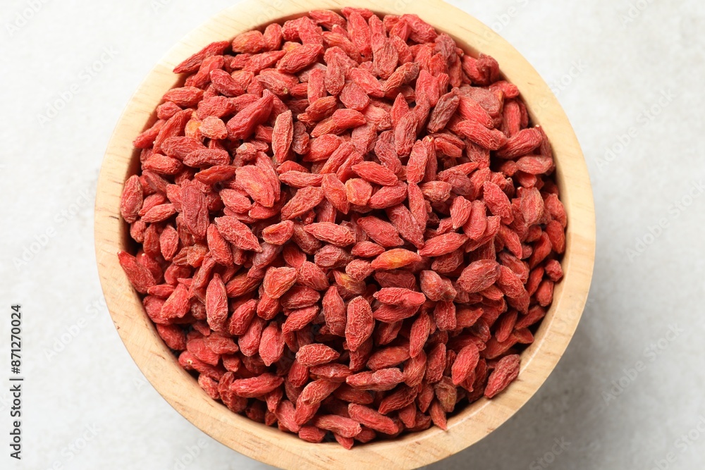 Dried goji berries in bowl on light table, top view Dried goji berries in bowl on light table, top view