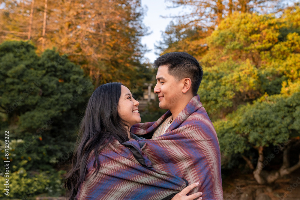 Heartwarming couple in love wrapped in blanket Heartwarming couple in love wrapped in blanket