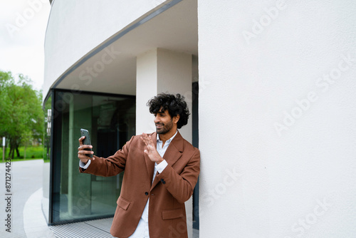 A man talks on a video chat standing outdoors photo